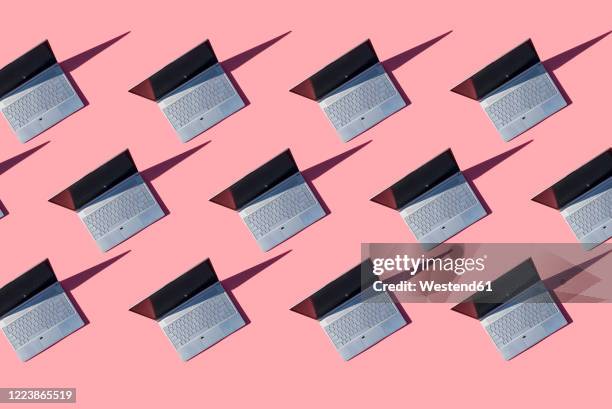laptops on pink background - repetition stock pictures, royalty-free photos & images