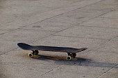 Old used Skateboard is standing on asphalt with tire tracks, Sofia