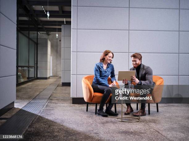 businessman with tablet and businesswoman having a meeting in modern office - meeting room stock-fotos und bilder