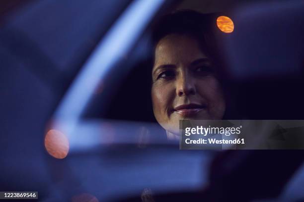 reflection of woman in rear-view mirror of a car at night - auto licht stock-fotos und bilder
