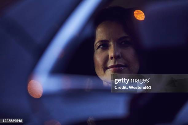 reflection of woman in rear-view mirror of a car at night - driver portrait fotografías e imágenes de stock