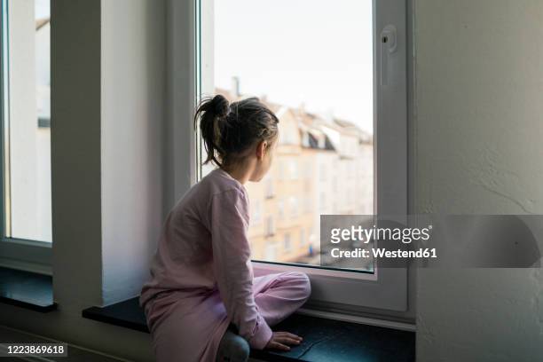 little girl looking out of window - exclusion stock-fotos und bilder