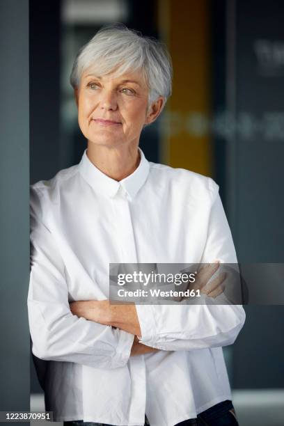 portrait of content senior businesswoman looking at distance - at a glance stock-fotos und bilder