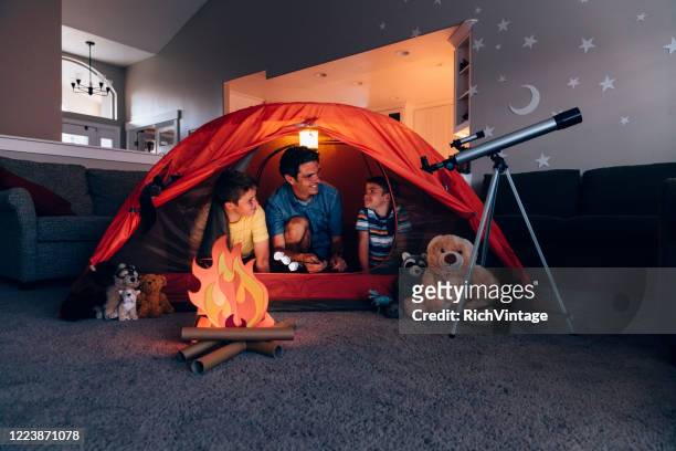 vater und söhne camping drinnen - freizeitaktivität stock-fotos und bilder