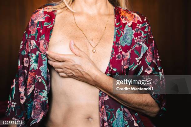 close-up of a senior woman touching her breast - seno foto e immagini stock