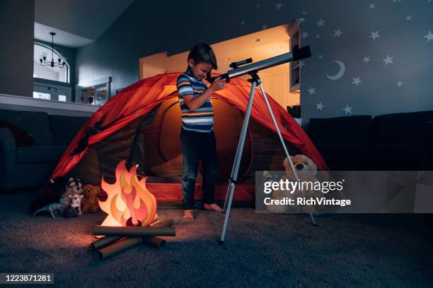 junge erkundet mit teleskop in innenräumen - kids room stock-fotos und bilder