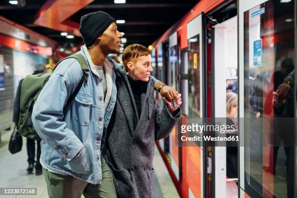 young couple at the station platform entering subway - entrer photos et images de collection