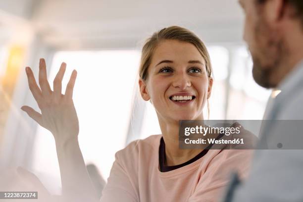 portrait of smiling young woman talking to man - handen over elkaar stockfoto's en -beelden