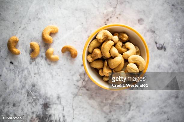 bowl of salted cashew nuts - cashewnuss stock-fotos und bilder