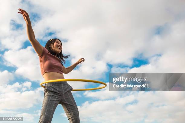 happy woman playing with hula hoop outdoors - plastic hoop stock pictures, royalty-free photos & images