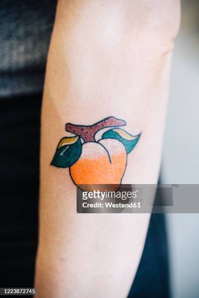 peach tattooed on woman's arm - fore arm stock pictures, royalty-free photos & images