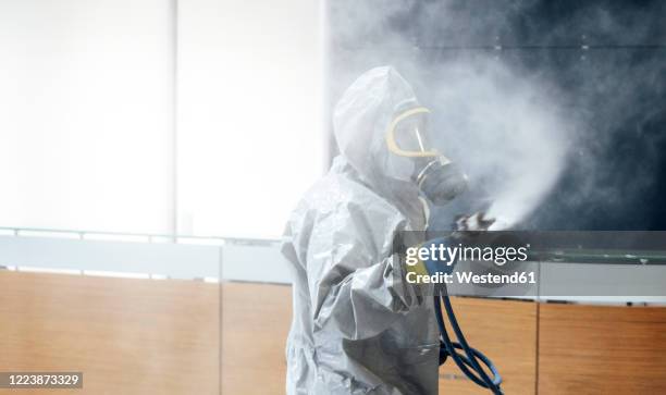 cleaning staff desinfecting hospital against contageous virus, wearing protective clothing - roupa protetora imagens e fotografias de stock