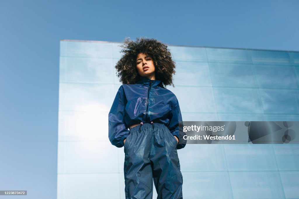 Portrait of stylish young woman wearing tracksuit outdoors