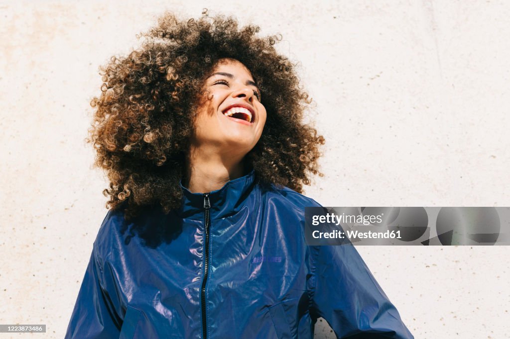 Portrait of happy stylish young woman wearing tracksuit outdoors