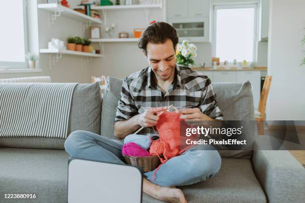 uomo che guarda il tutorial di lavoro a maglia con aghi - a maglia foto e immagini stock