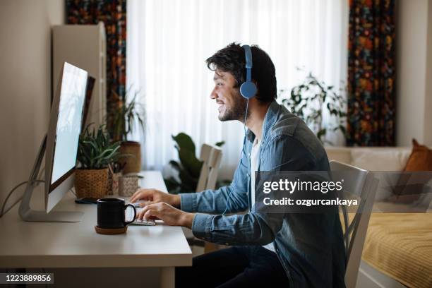 jonge mens die van huis werkt - exam desk stockfoto's en -beelden