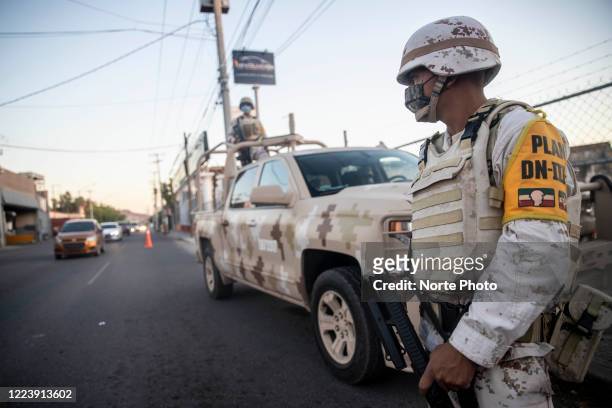 Soldiers of the Mexican army support local police in an operation to measure the temperature to drivers on May 9 29, 2020 in Hermosillo, Mexico....