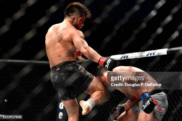 Henry Cejudo of the United States knees Dominick Cruz of the United States in their bantamweight title fight during UFC 249 at VyStar Veterans...