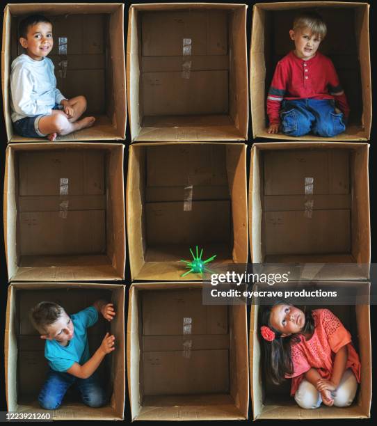 social distancing virus prevention small children inside enclosure series involving cardboard box related to shelter in place during illness crisis - box trap stock pictures, royalty-free photos & images