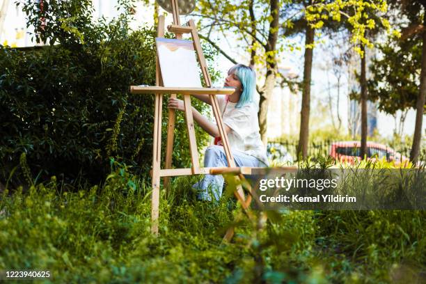 junge schöne frau malerei ein bild auf leinwand - art easel stock-fotos und bilder