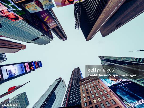 low angle view of skyscrapers in times square at dusk - times square stock pictures, royalty-free photos & images