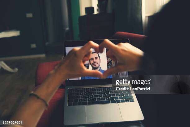 mujer en videollamada con su pareja - relaciones sociales en los tiempos de distanciamiento social de covid19 - online dating fotografías e imágenes de stock