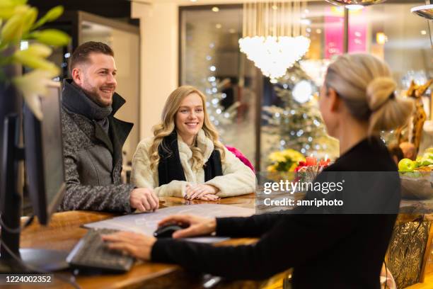 rich couple on first class trip at hotel reception - vip reception stock pictures, royalty-free photos & images