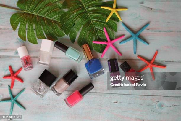 colorful nail polish on blue table - nagelfeile stock-fotos und bilder