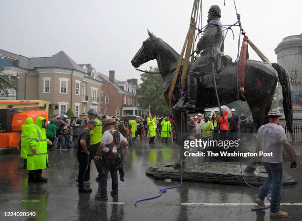 Crane crew places the statue of confederate general Stonewall Jackson on the ground after removing it from it's pedistal located at the intersection...