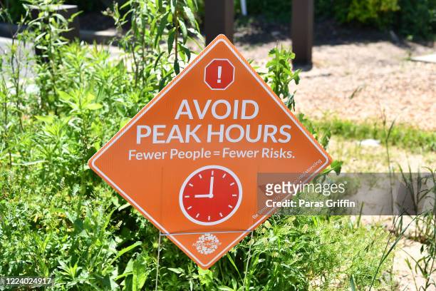 Sign displays "Avoid Peak Hours, Fewer People = Fewer Risks." at the Atlanta Beltline as the coronavirus pandemic continues on May 10, 2020 in...