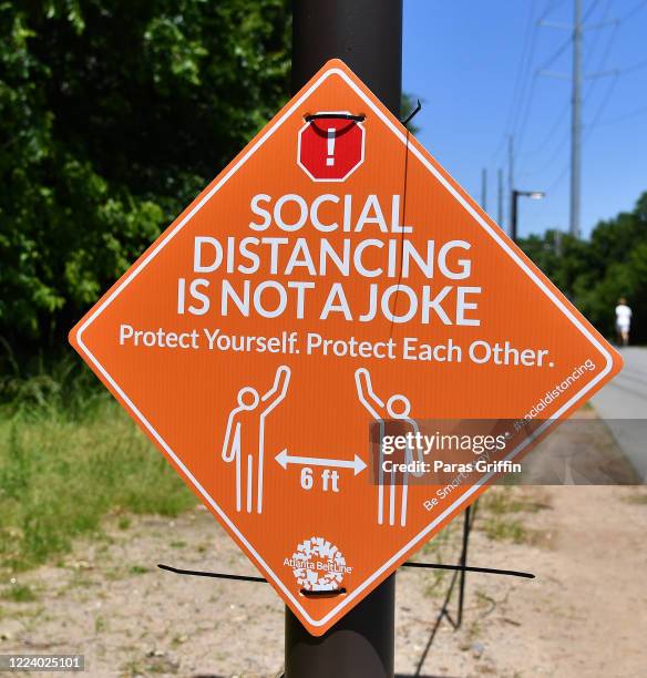 Sign displays "Social Distancing Is Not A Joke, Protect Yourself. Protect Each Other." at the Atlanta Beltline as the coronavirus pandemic continues...