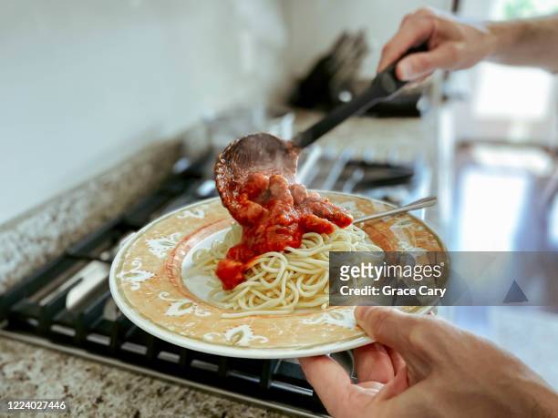 man pours sauce over pasta - sauce stock pictures, royalty-free photos & images