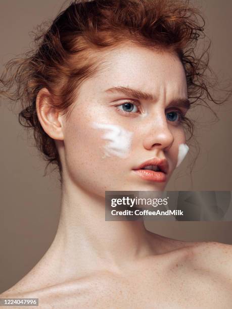 portrait of the beautiful young woman who's applies skin cream - face cream stock pictures, royalty-free photos & images