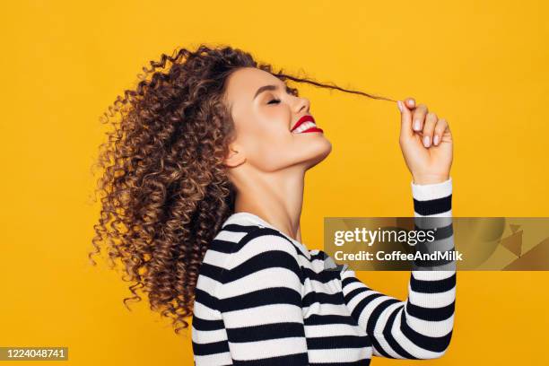 funky young girl against yellow background - curly hair stock pictures, royalty-free photos & images