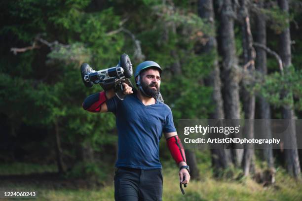 skateboard rider holding his electric off road skateboard. - electric motorsport stock pictures, royalty-free photos & images