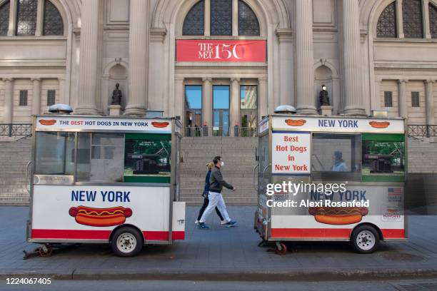 People wearing masks walk past the Metropolitan Museum of Art amid the coronavirus pandemic on May 10, 2020 in New York City. COVID-19 has spread to...