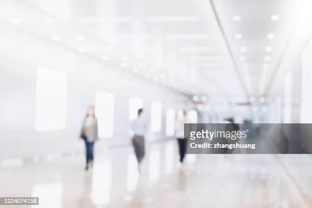 blurred background of businesspeople standing in the corridor of an business center - unscharf gestellt stock-fotos und bilder