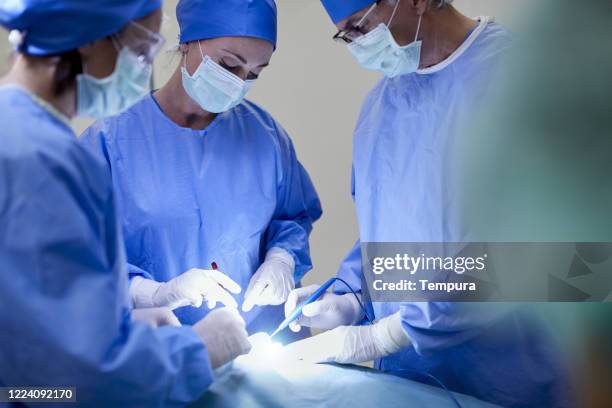 close up view of surgeons suturing a wond in the operation table. - centro cirurgico imagens e fotografias de stock