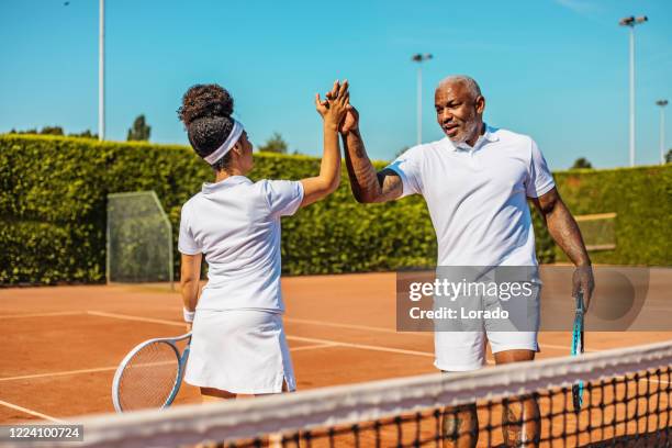 una hermosa tenista negra en la cancha con su padre entrenador - club de campo fotografías e imágenes de stock