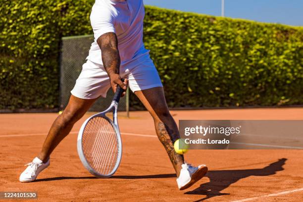 a handsome black middle aged male tennis player on the court - amateur tennis man stock pictures, royalty-free photos & images