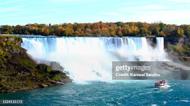 the colourful american falls with ferry in front and autumn colours as backdrop - horseshoe falls niagara falls fotografías e imágenes de stock