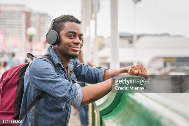backpacker listening to music at darling harbor bridge sydney - darling harbor stock pictures, royalty-free photos & images