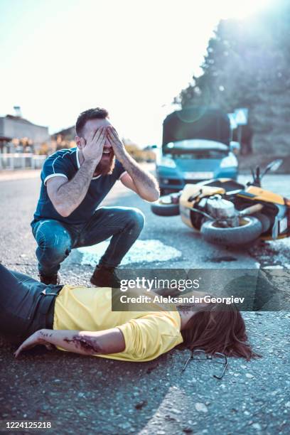 male crying over female motorcyclist he hit with car - accident victim stock pictures, royalty-free photos & images