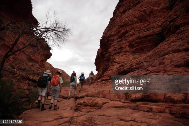 tourists hiking in kings canyon national park outback central australia. - uluru kata tjuta national park stock pictures, royalty-free photos & images