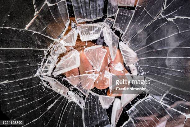 hand breaking glass window - punching stock pictures, royalty-free photos & images