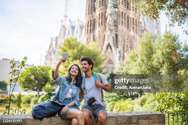young couple taking break from sightseeing for selfie - sagrada familia barcelona stock pictures, royalty-free photos & images