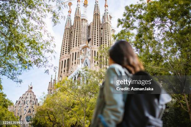 female sightseer walking near sagrada familia in barcelona - sagrada família imagens e fotografias de stock