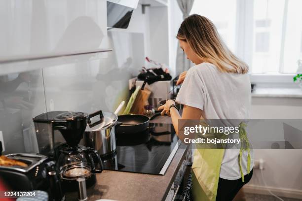 young woman preparing breakfast - woman breaking plates stock pictures, royalty-free photos & images