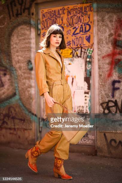 Lea Neumann wearing Prada bag, Jeffrey Campbell cowboy boots and Gestuz overall on May 06, 2020 in Berlin, Germany.