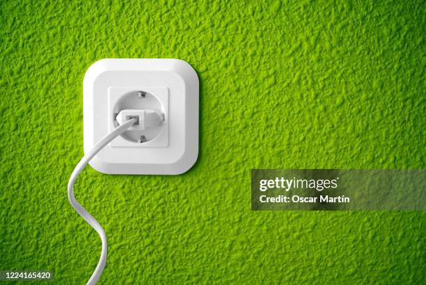 plug for sustainable green energy - enchufe fotografías e imágenes de stock